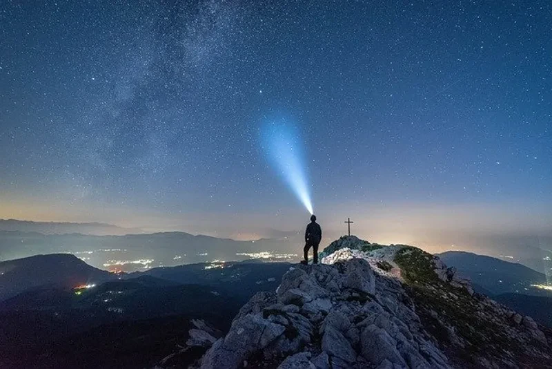 A man on a hill with a flashlight