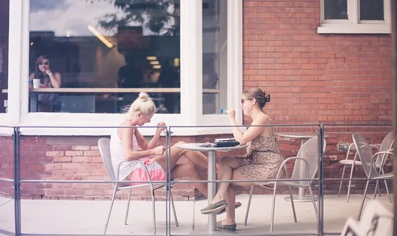Two women sitting at a table outdoors