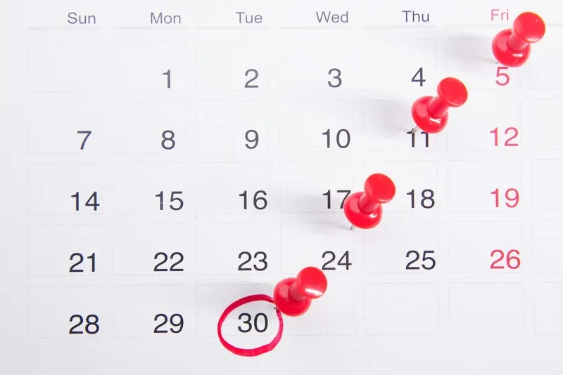 Un calendario con chinchetas rojas