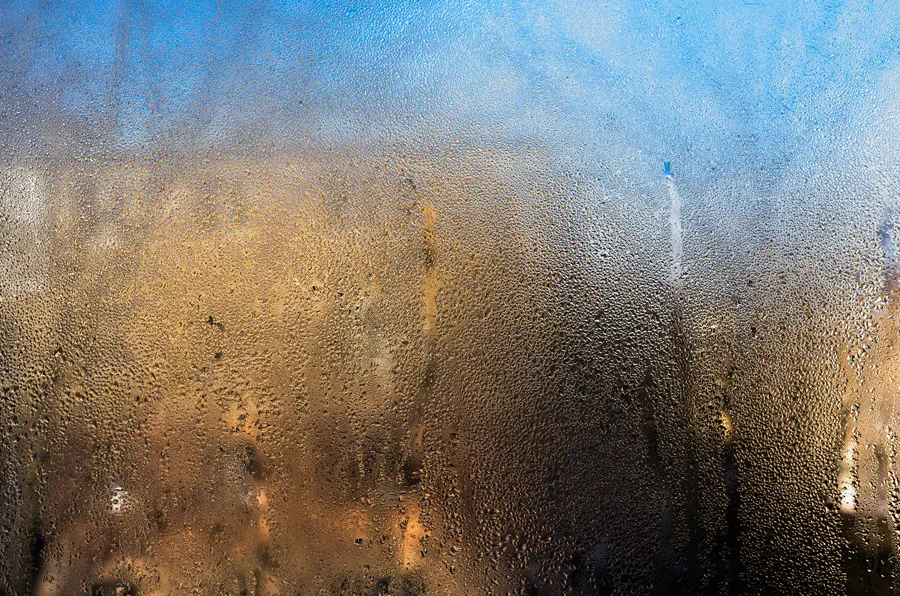 Close-up of a window with condensation forming on the glass.