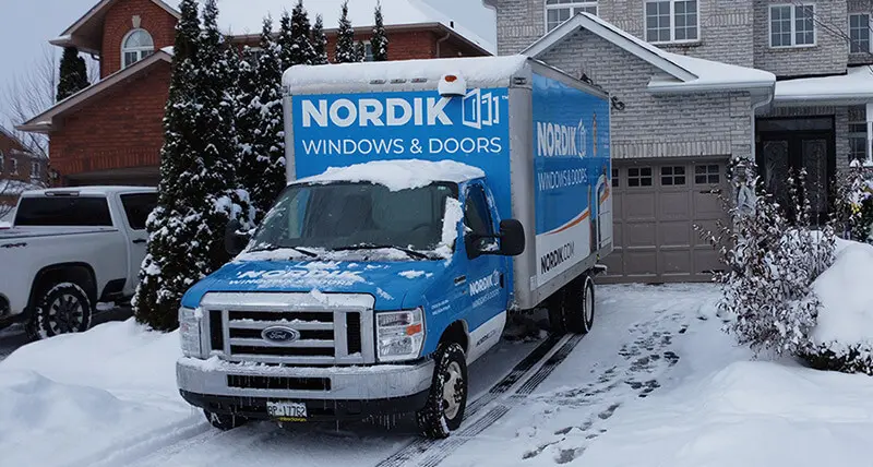 A Nordik installation truck drives through a suburban neighbourhood in the winter time.