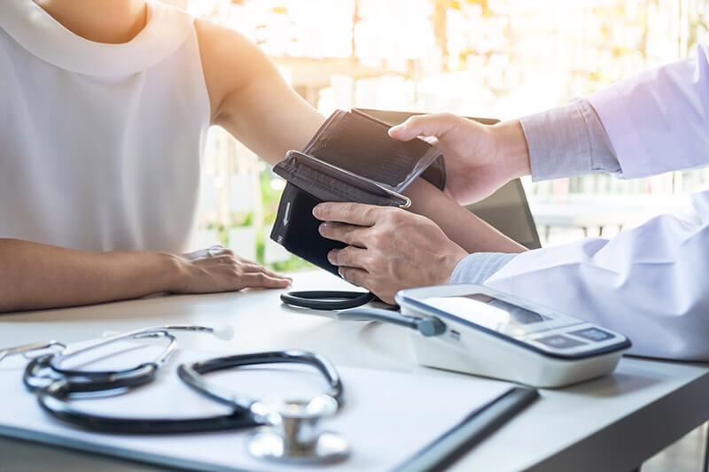 A doctor checks a patient's blood pressure.