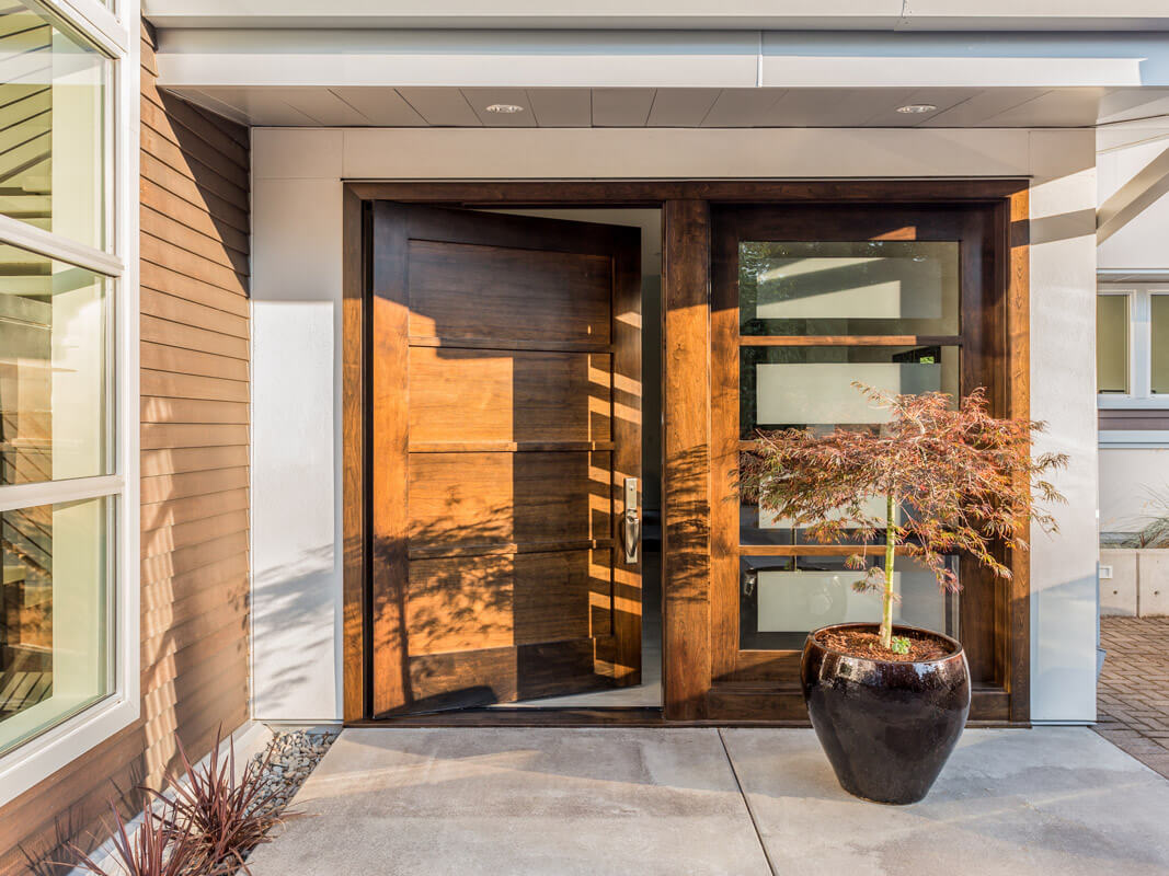 Large, double-wide wooden door on a modern home