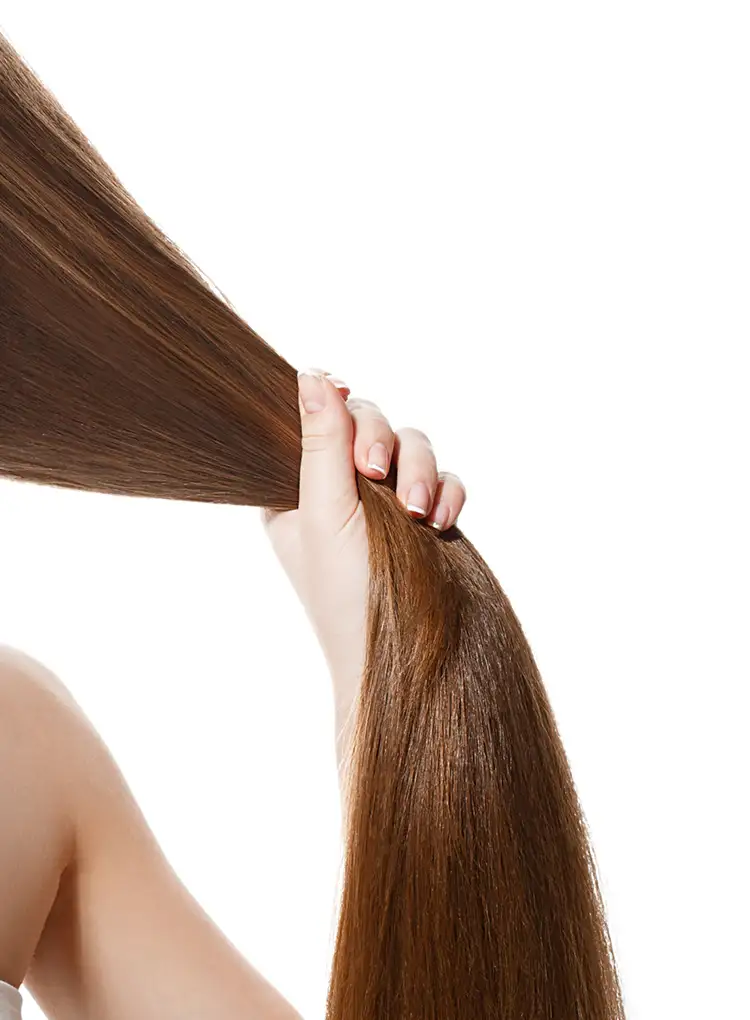 Mulher segurando seus cabelos longos e saudáveis