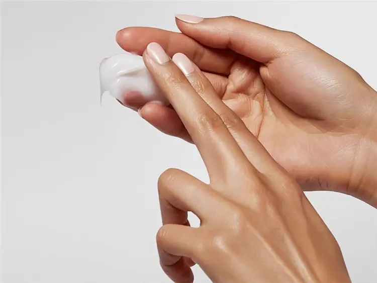 Mulher aplicando o creme para pentear o cabelo da Pantene