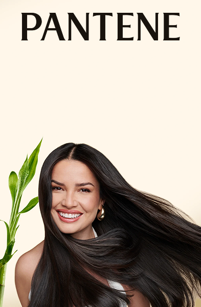 Mulher com cabelo liso ao lado de uma planta de bambu