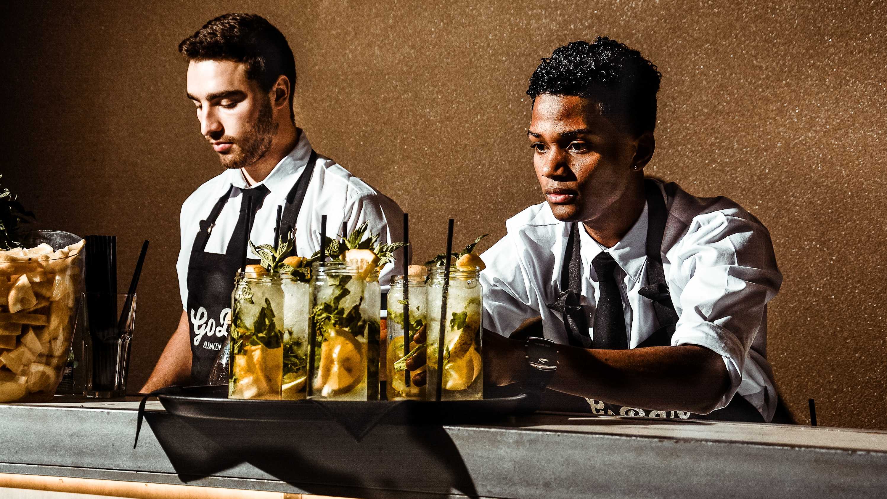 two bartenders serving drinks
