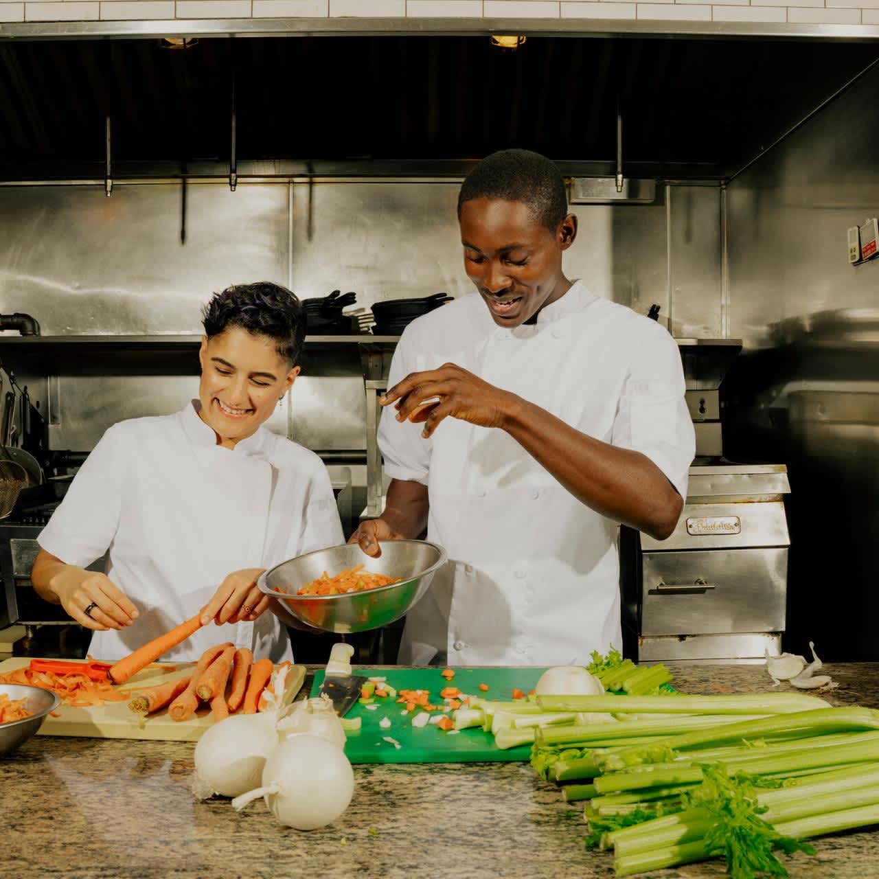 two chefs prepping vegetables for service