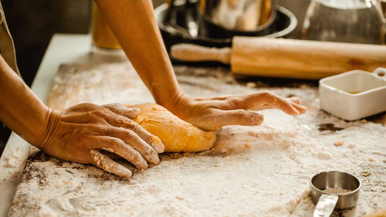 woman chef rolling dough in the kitchen