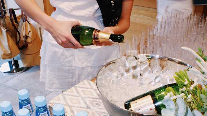 server pouring golfers champagne and water