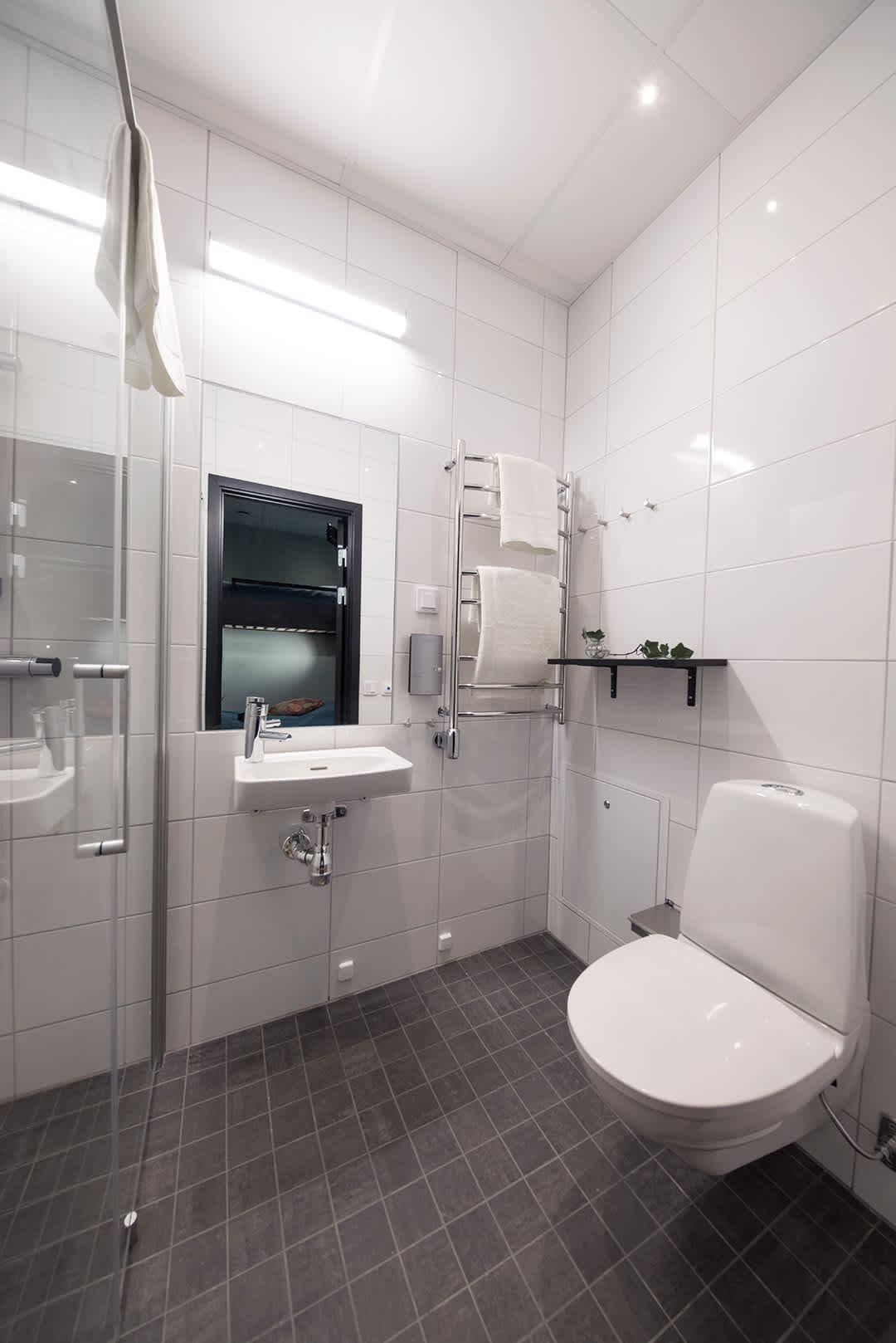 Room Carma at Staykvick Boutique Hostel. A spacious bathroom with a shower and a toilet.