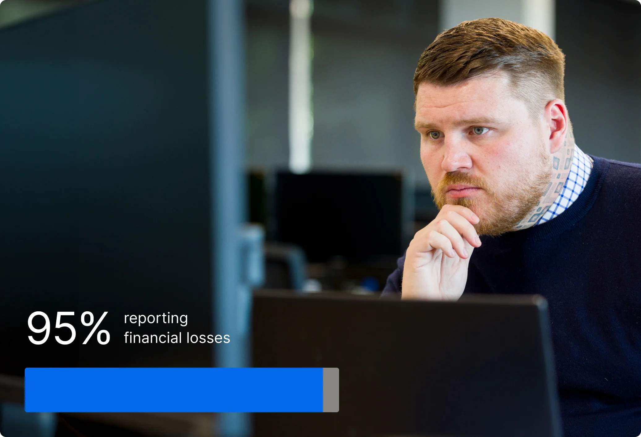 Police officer in uniform working at computer in dark room with statistic showing 95% reporting financial losses.