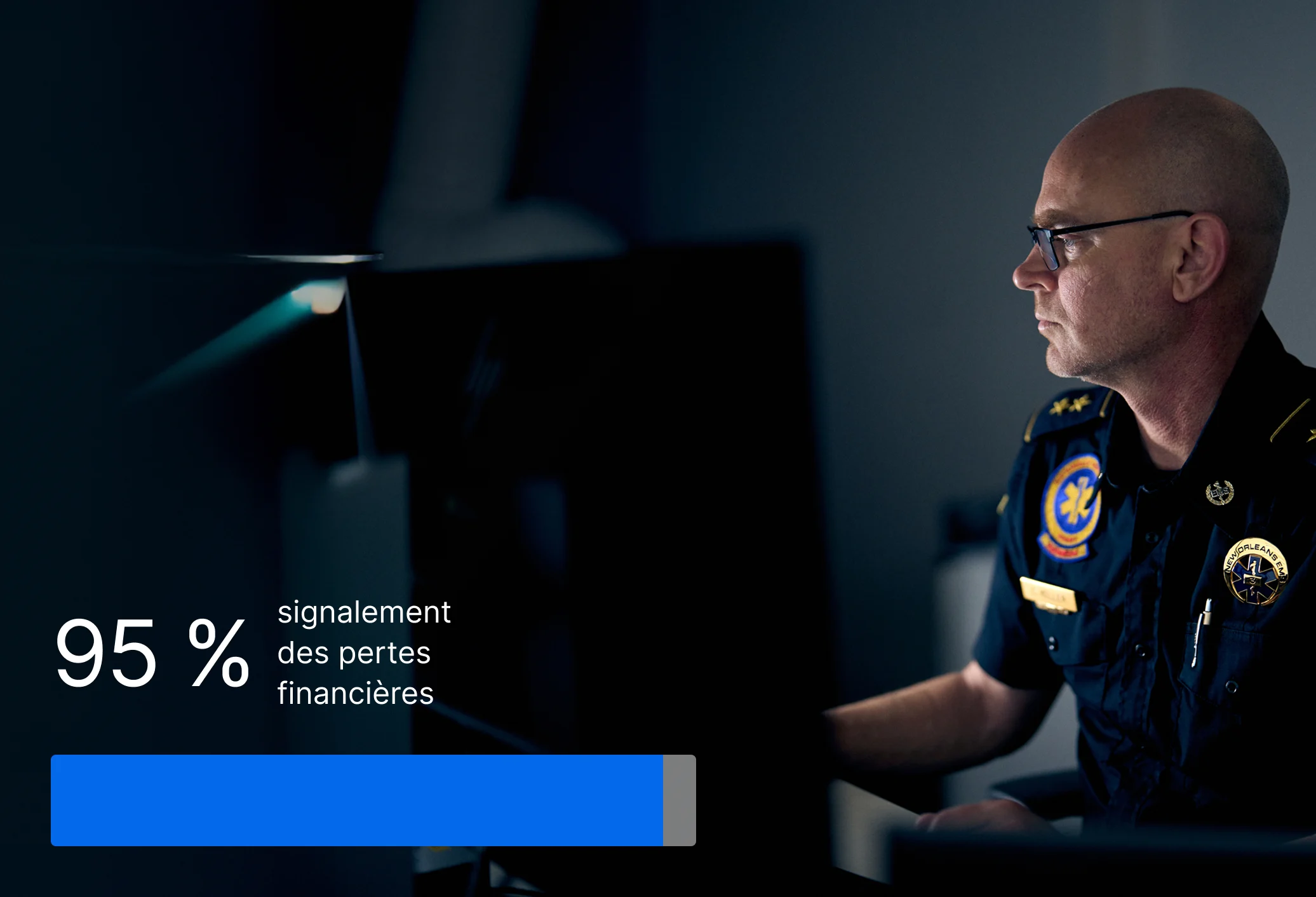 Policier sur un ordinateur dans une pièce sombre avec des statistiques montrant que 95 % ont déclaré des pertes financières.