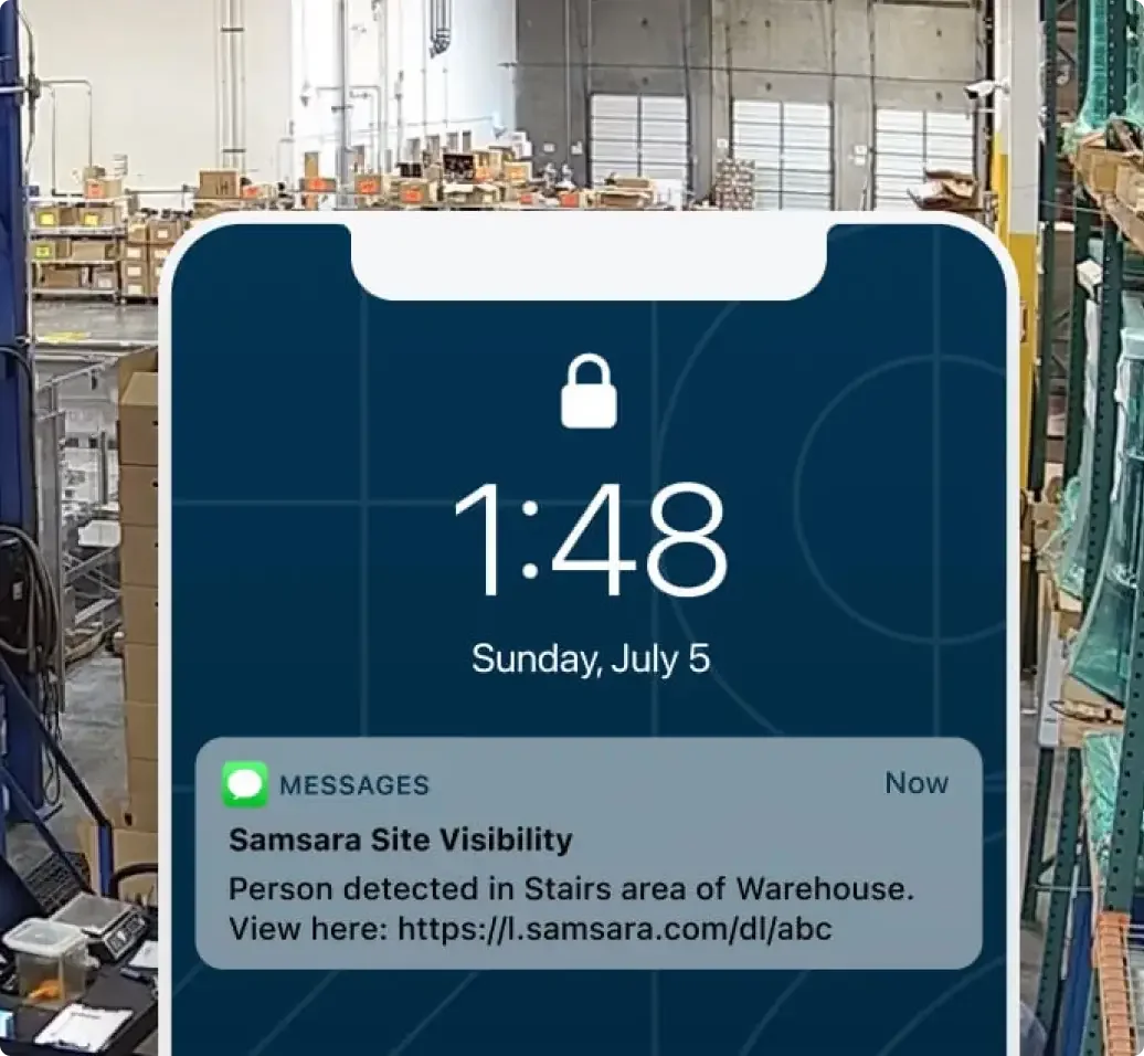 Phone screen showing security alert "Person detected in Stairs area of Warehouse" overlaid on warehouse interior with boxes.