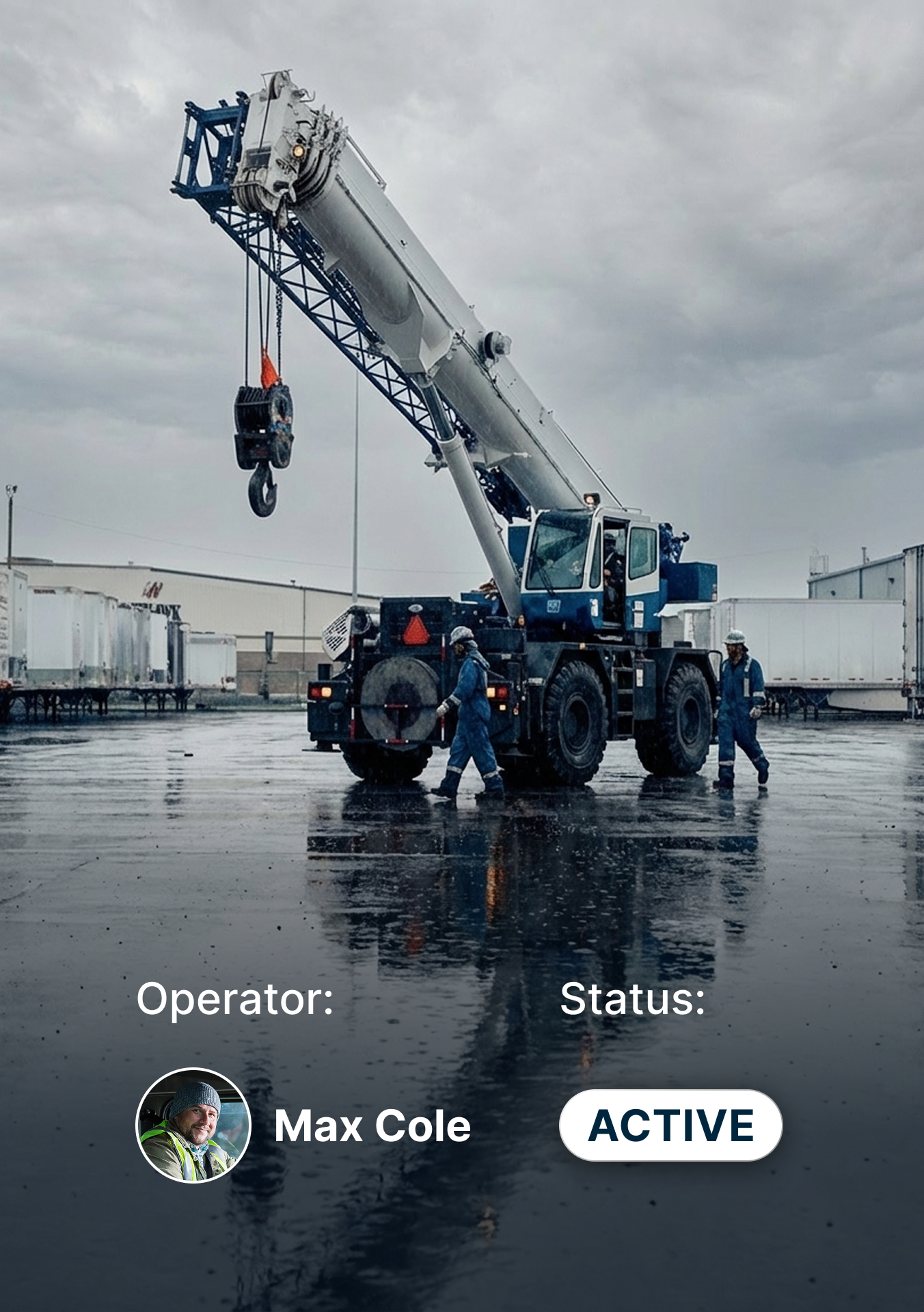 Mobile crane operating on wet industrial site with workers in blue coveralls, showing active operator status.