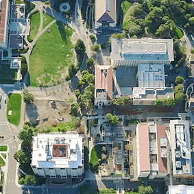 Aerial view of a university campus with buildings, green spaces, and pathways arranged in a grid pattern.