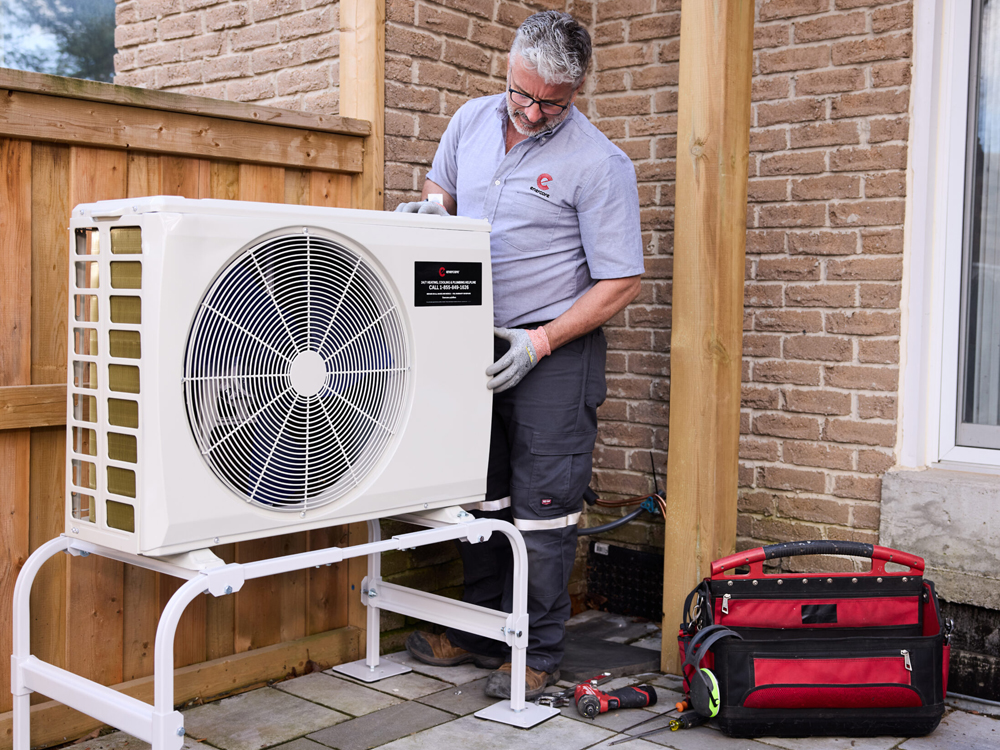 Enercare employee inspecting outdoor fan with red tool bag