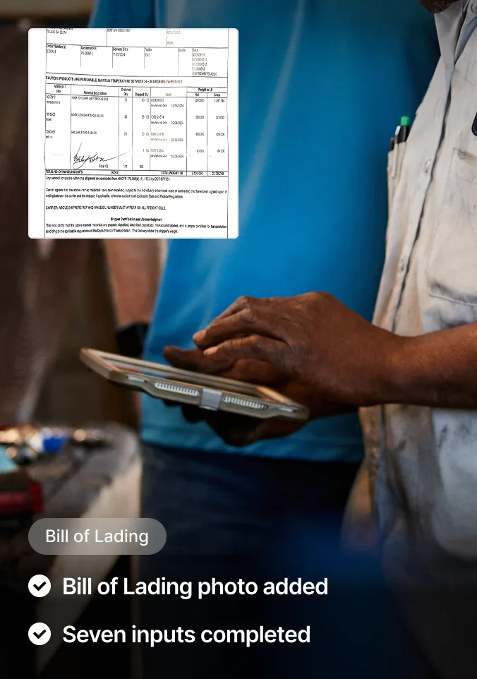 Person in light shirt holding tablet with bill of lading document displayed, showing shipping details and signature.
