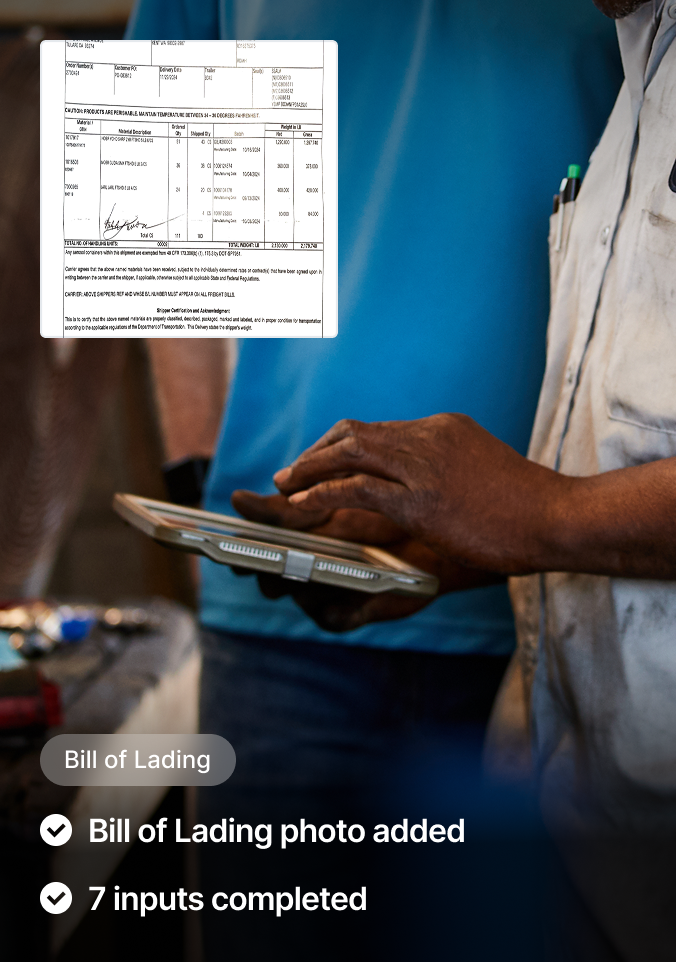 Person in light shirt holding tablet with bill of lading document displayed, showing shipping details and signature.