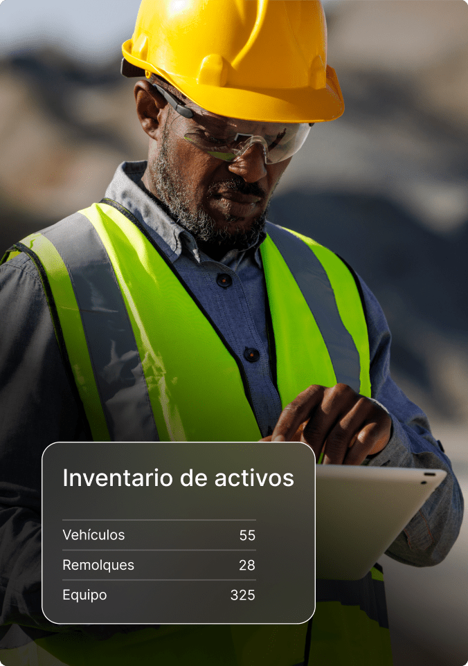 Albañil con casco y chaleco de seguridad con tableta para revisar el inventario de activos de vehículos, remolques y equipos.