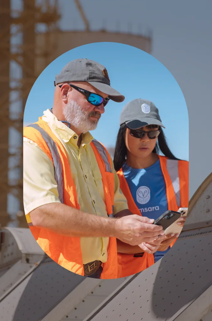 Two onsite workers reviewing smartphone data next to one another to inform their everyday operations.