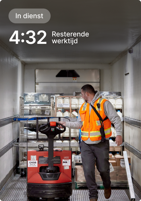 Werknemer in oranje veiligheidshesje bedient palletwagen in bestelbusje met 4:32 resterende dienst weergegeven op scherm.