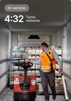 Trabajador operando transpaleta en camión de reparto con una pantalla que muestra 4:32 de turno restante.