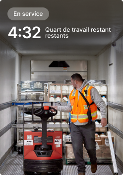 Un employé actionne un transpalette dans un camion de livraison avec un écran indiquant qu'il reste 4 h 32 au poste.