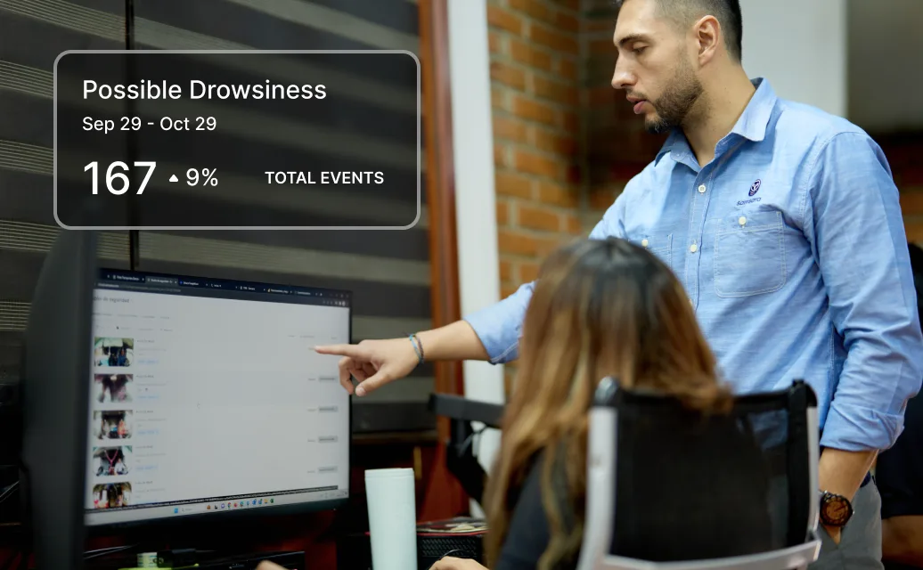 man pointing at screen reviewing driver behaviour