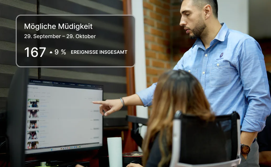 Mann zeigt auf Bildschirm, der das Verhalten des Fahrers überprüft