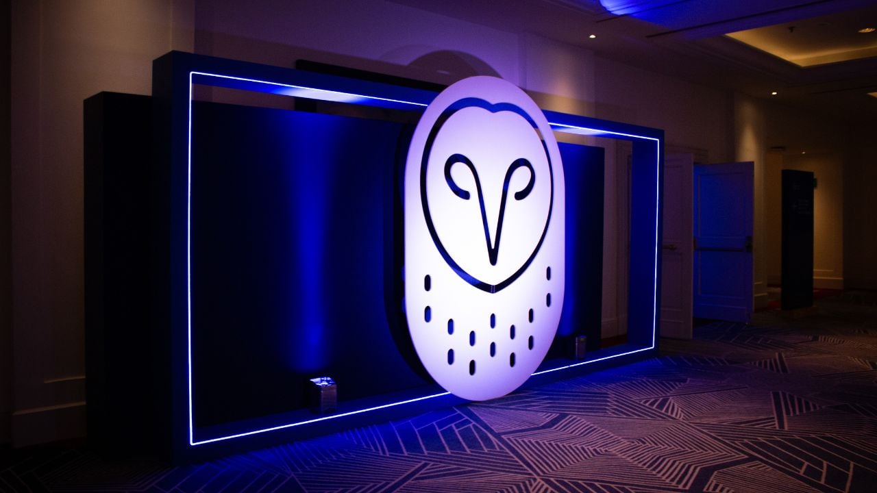 Logotipo de Samsara iluminado con contorno azul en exhibición con marco de luz neón azul en ambiente oscuro.