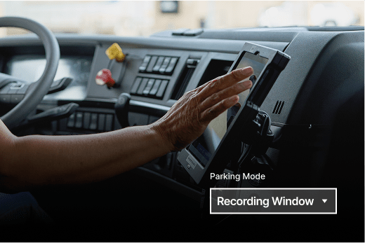 Hand adjusting a dashboard device in a truck cab showing "Parking Mode" and "Recording Window" interface options.