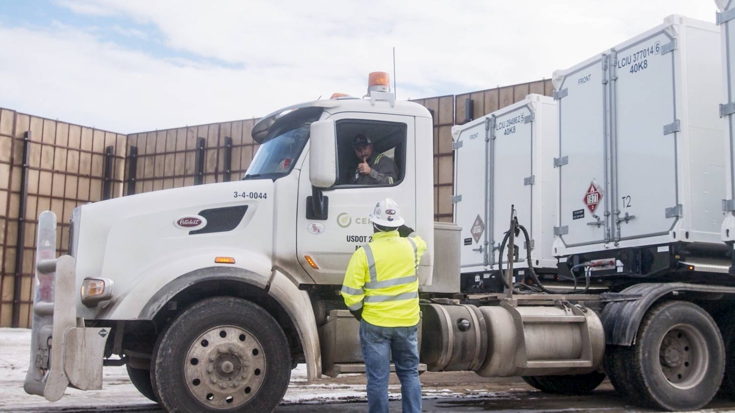 Worker talking to a driver in a truck.