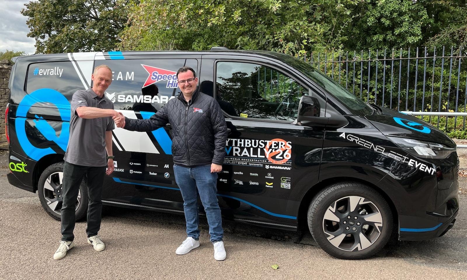 Kristopher Parks of Speedy Hire and Jim Hill of Samsara pose in front of an electric van at the EV Rally 2026