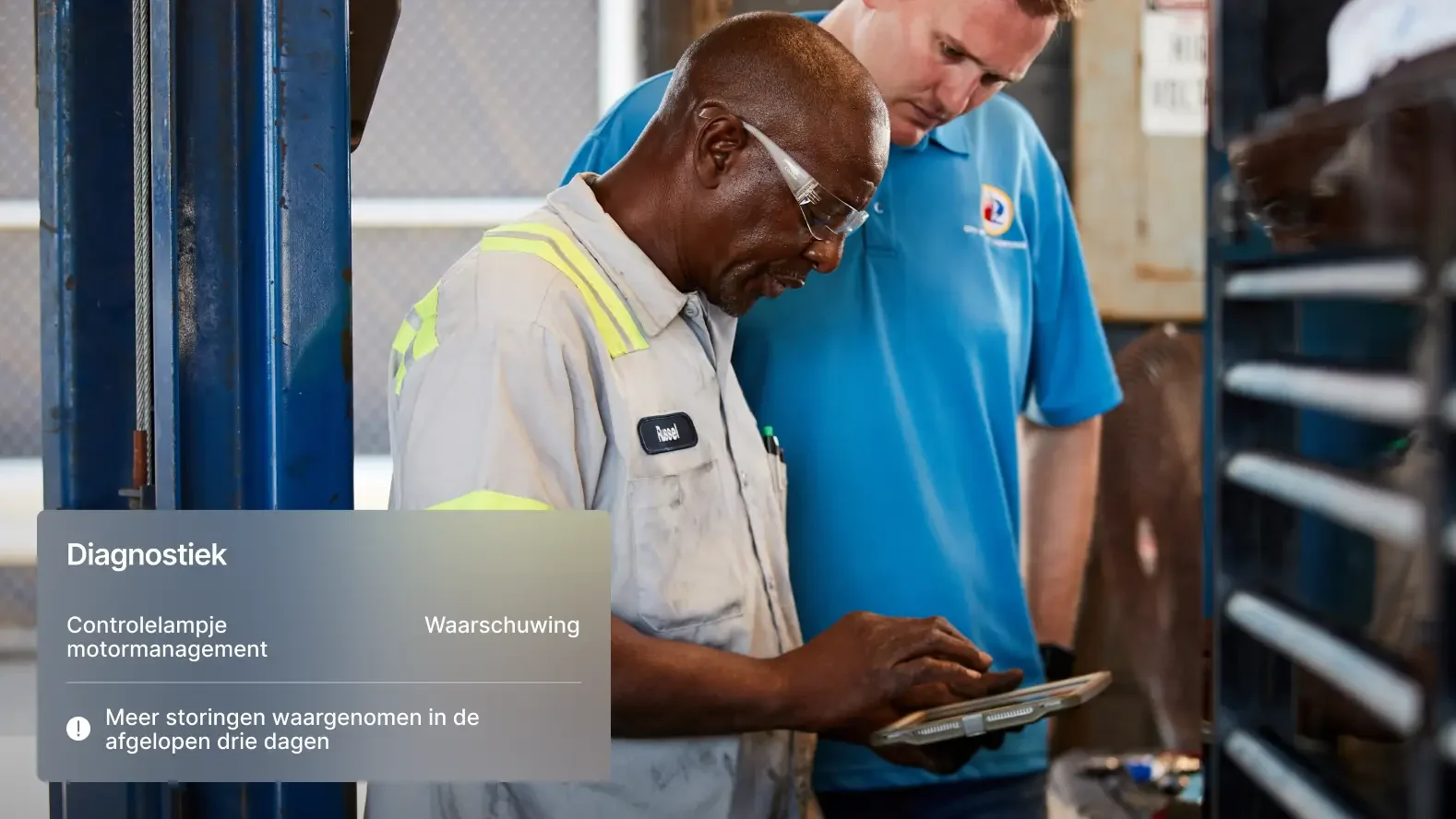 Twee monteurs bekijken voertuigdiagnose op een tablet met waarschuwingen over problemen met motorstoringslampjes.