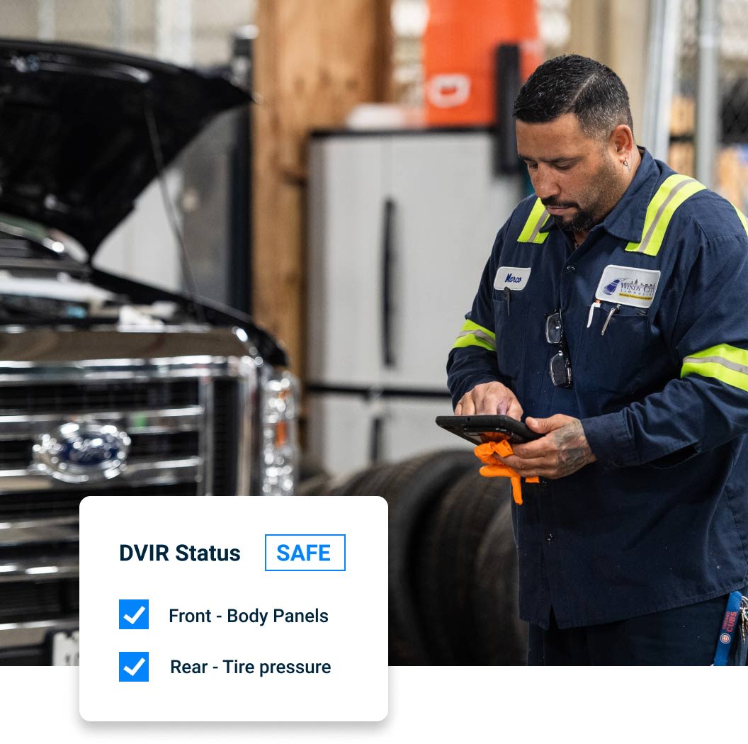 Mechanic on an iPad next to a truck with hood up. Overlay of DVIR Status: SAFE for Front - Body Panels, Rear - Tire pressure