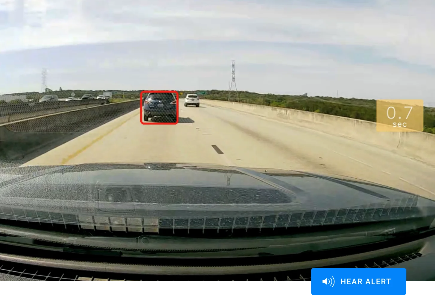 Vue depuis un pare-brise sur une autoroute avec voitures en circulation, un véhicule encadré en rouge et un compteur indiquant 0,7 sec.
