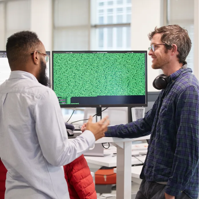 Samsara employees discussing and working at the computer.