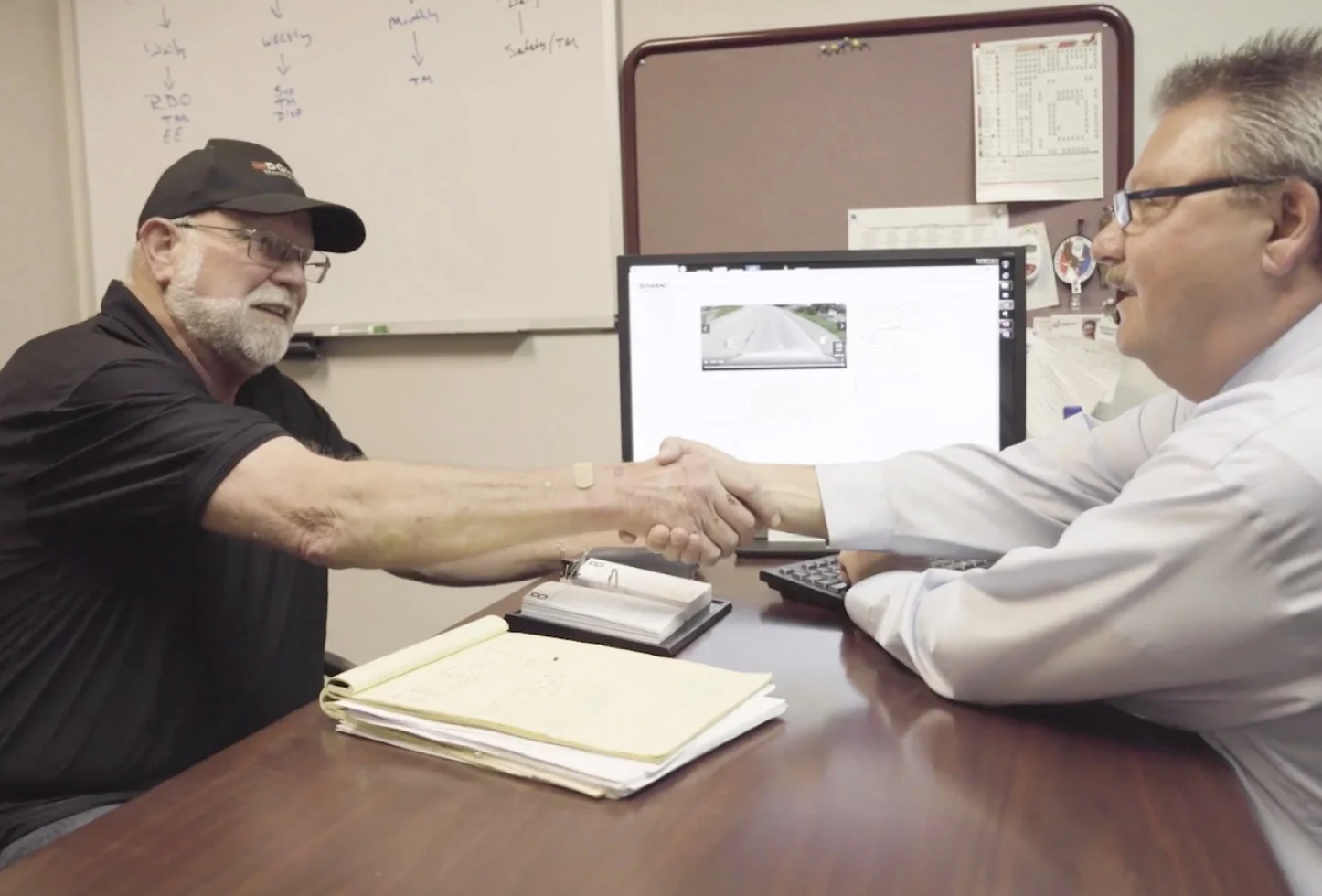 Video thumbnail of two men shaking hands across the table in front of a computer