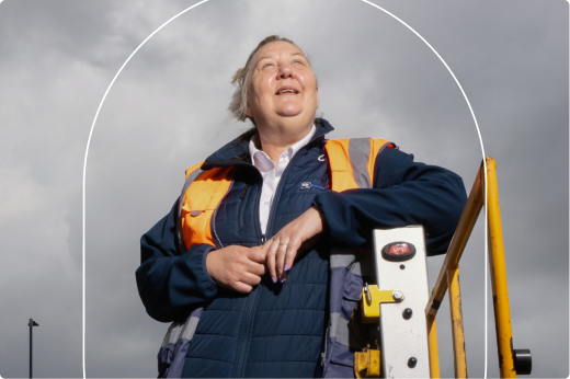 Rettungssanitäter mit neongelber New Orleans EMS-Weste, schwarzer Kappe und Sonnenbrille steht neben Fahrzeugen.