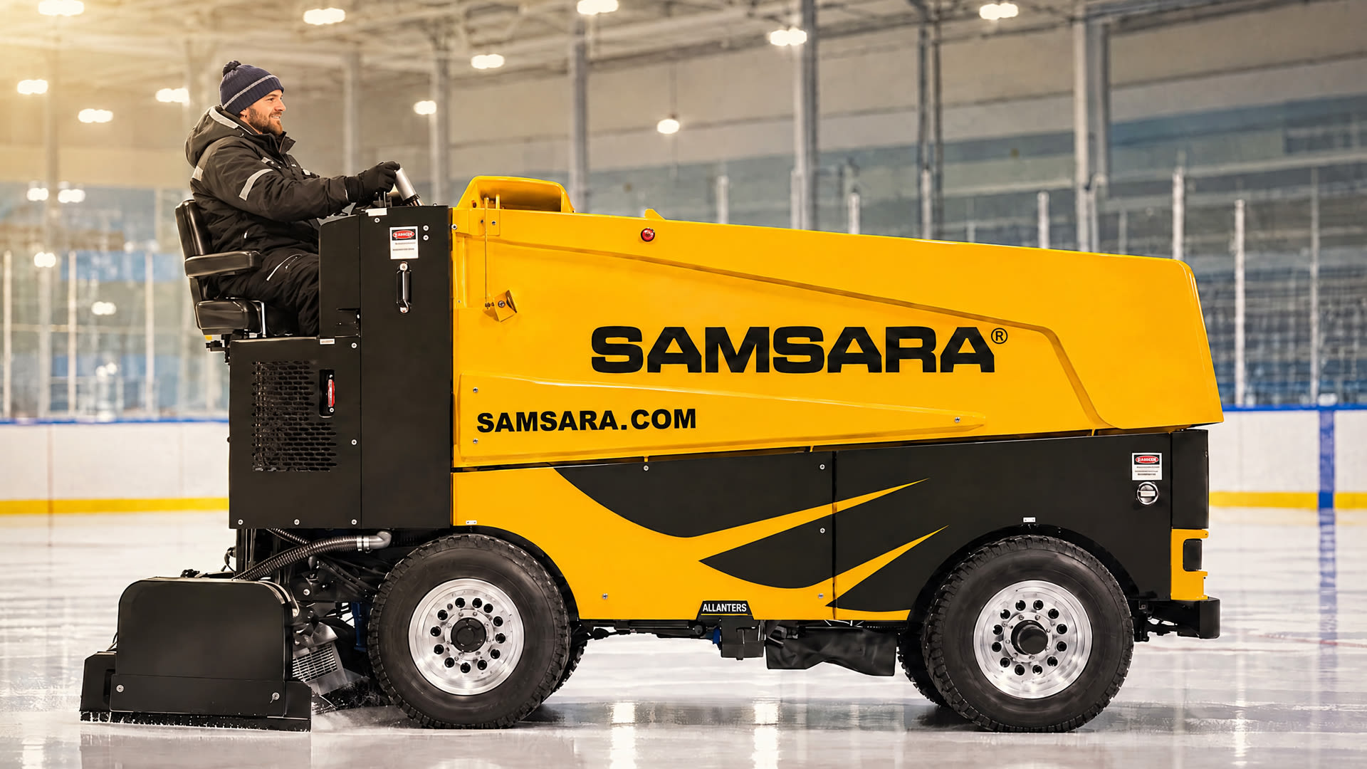 Yellow Samsara-branded Zamboni on the ice with operator wearing a toque.