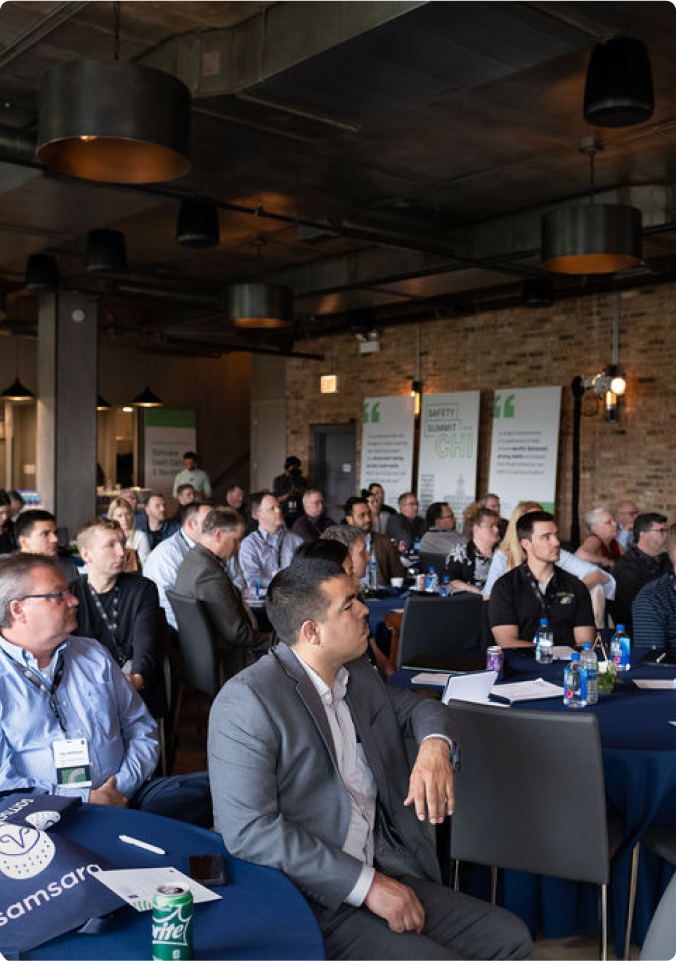 view of people sitting at table listening to presentation
