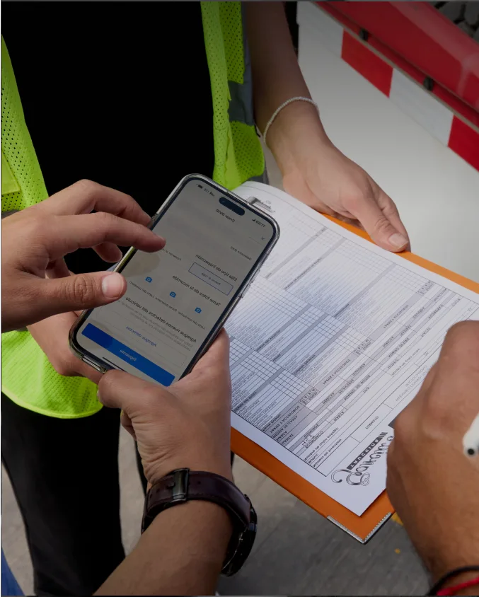 Dos trabajadores de pie uno al lado del otro usando la aplicación Samsara en un iPad.