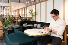 Samsara Employee sitting in a Samsara lounge in Paris area looking at their phone.