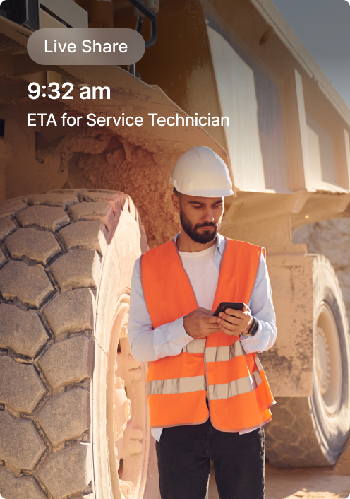 Construction worker in orange safety vest checking phone next to large equipment, with service technician ETA display.