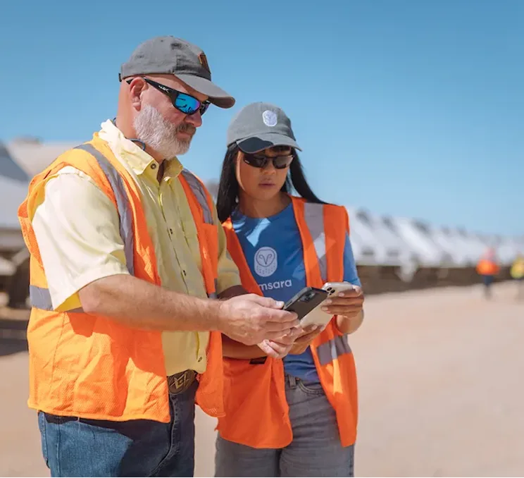 two workers looking at a phone