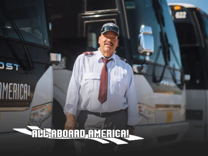 All Aboard America employee proudly stands in front of buses.