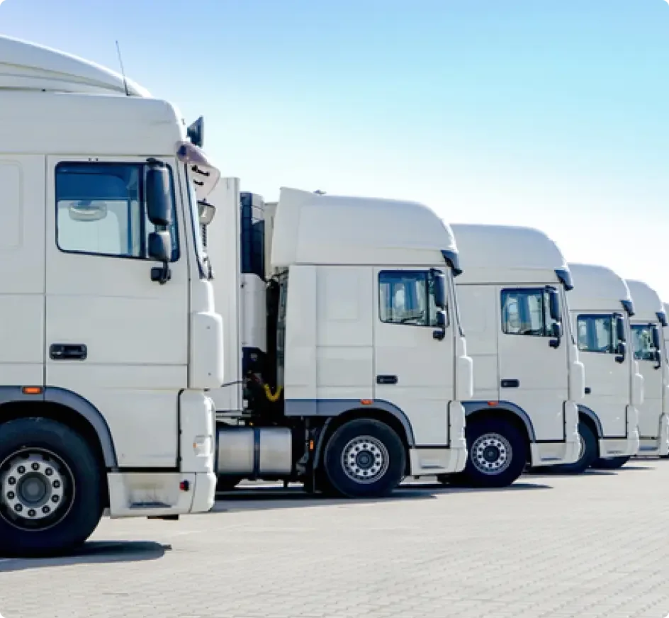 Camión semirremolque azul con remolque plateado circulando por la autopista con fondo de bosque perenne