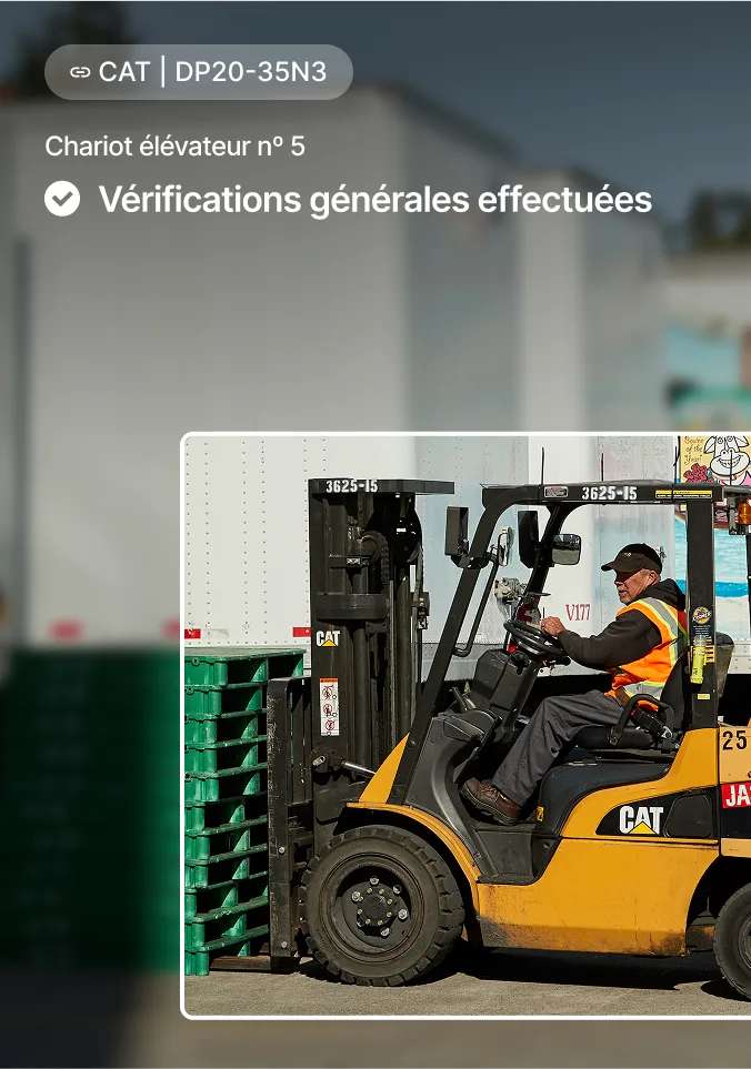 Un opérateur portant un gilet conduit un chariot élévateur CAT avec des palettes, indiquant que l'inspection est terminée.