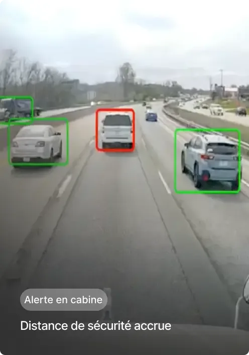 Vue d'autoroute depuis le véhicule montrant la circulation avec des voitures surlignées et une alerte dans la cabine.